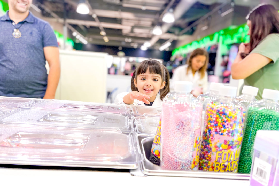 Slimeatory staff helping a customer create custom slime at the DIY Slime Bar